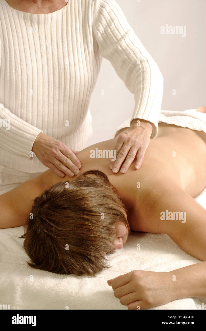 A man is a chiropractor doing a massage to a woman in the neck and trapezius  muscles in his office Stock Photo - Alamy