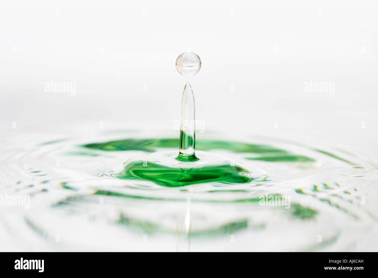 Water drop on white water mirrored surface Stock Photo