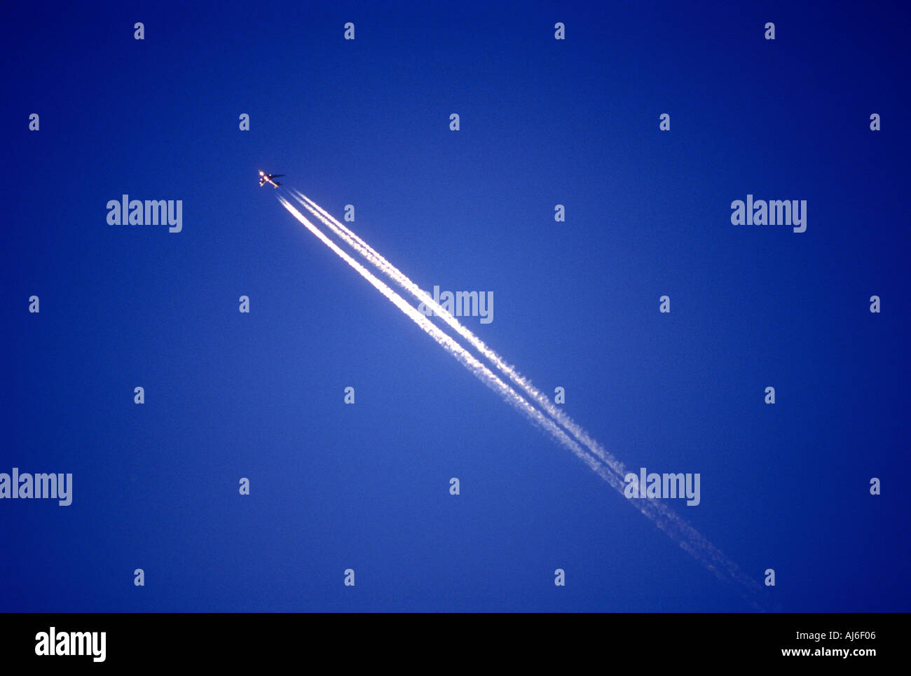 Commercial passenger airliner and vapor trail in sky Stock Photo