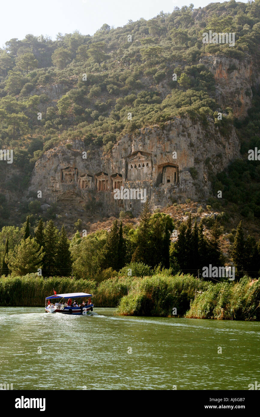 Fourth century rock tombs in the Lycian style near Kaunos Dalyan Turkey with boat in the foreground  Stock Photo