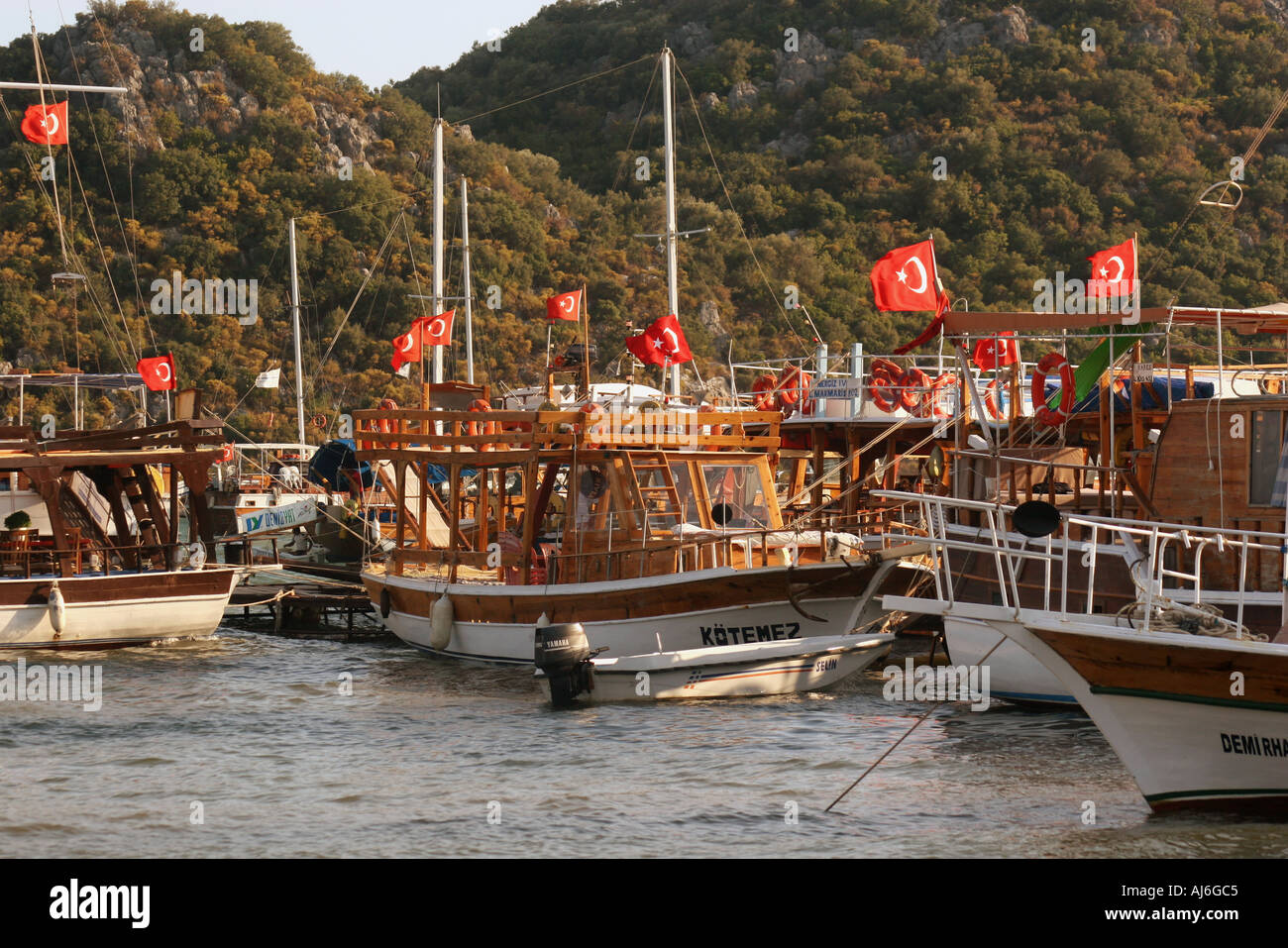 Yachts and gulets moored in Ucagiz harbour Anatolia southern Turkey with many flags  Stock Photo