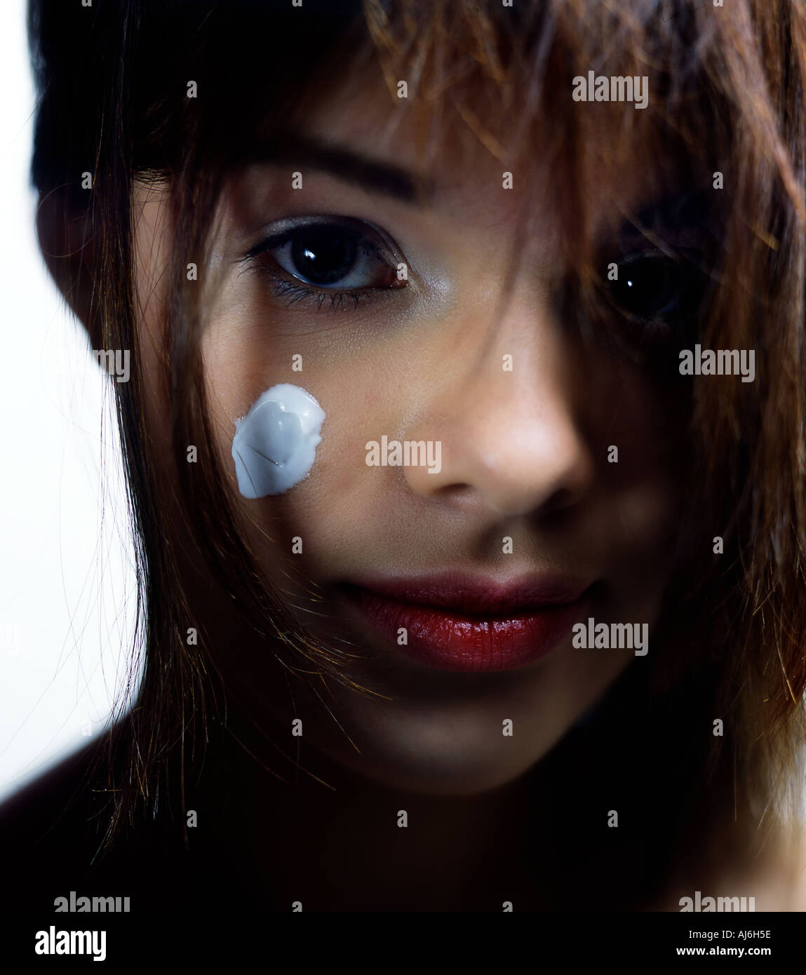 Portrait of a young woman with some cream on her facce. Stock Photo