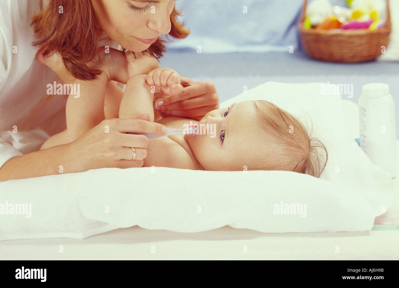 Woman measuring her baby's temperature. Stock Photo