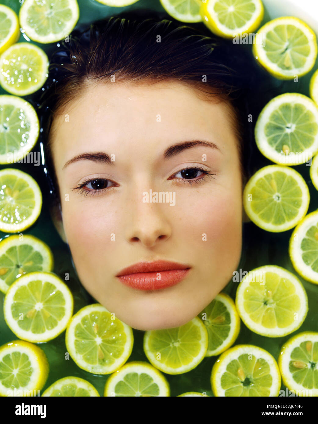 Woman taking bath with citrus slices. Stock Photo