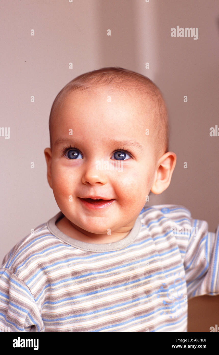 vertical toddler 0 5 fair skinned blue eyed big blue eyes stand standing happy glad smile smiling curious Stock Photo