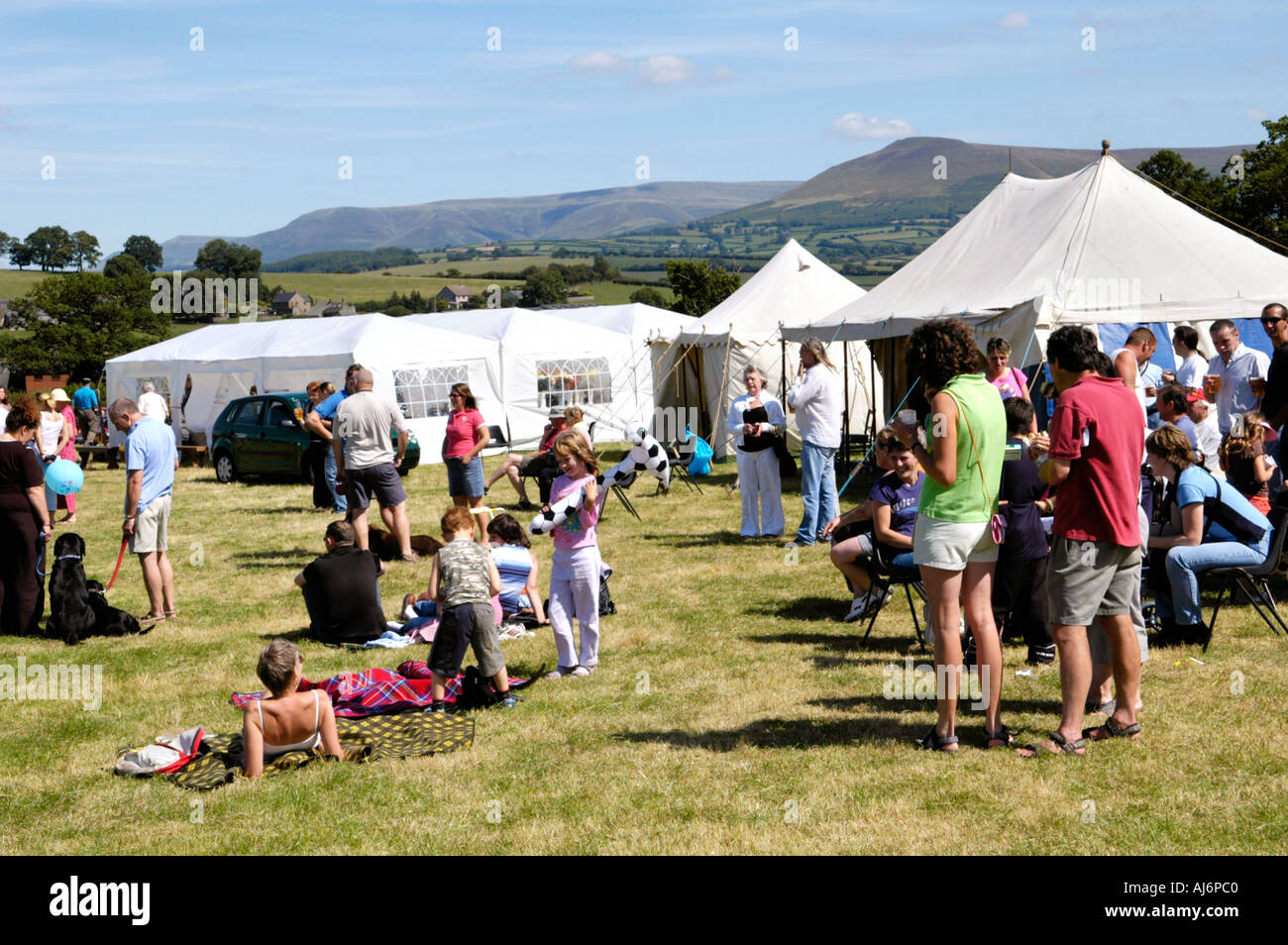 People relaxing in the sunshine on showground at Llanfihangel Talyllyn