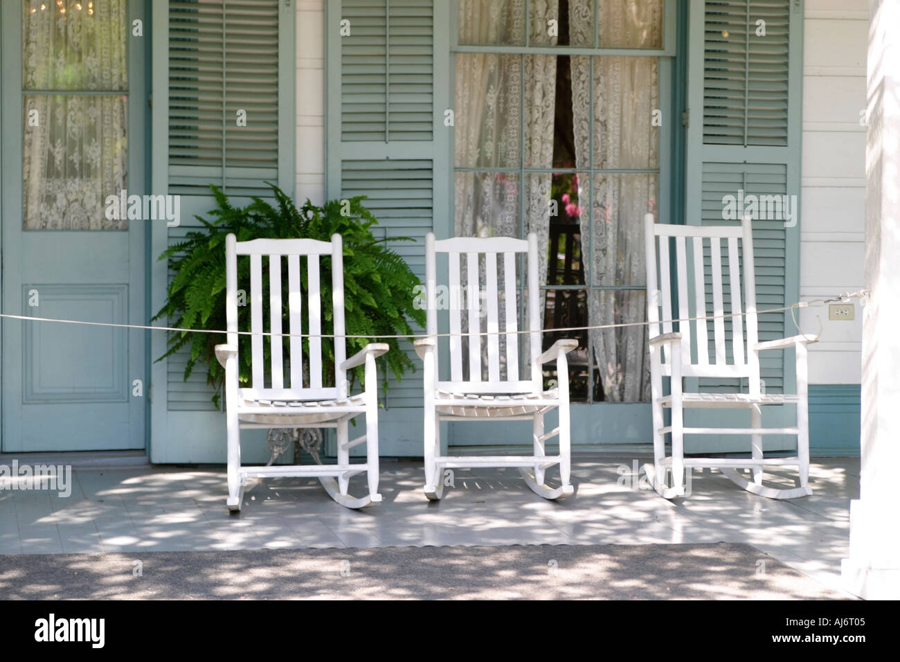 Three rocking chairs on porch Stock Photo - Alamy