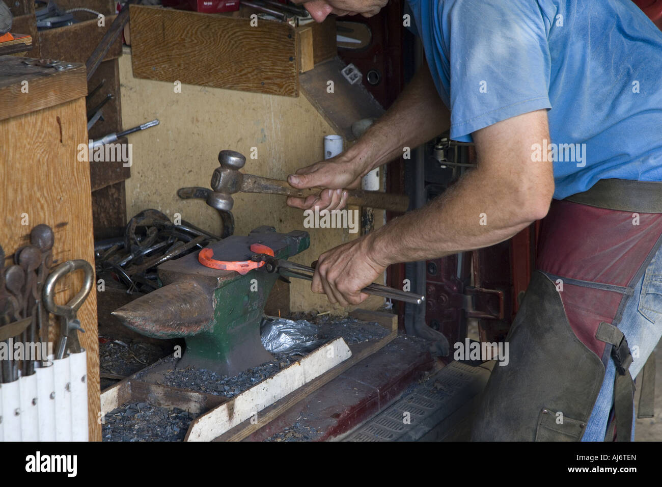 Farrier heating metal on forge for making Horse Shoe Stock Photo