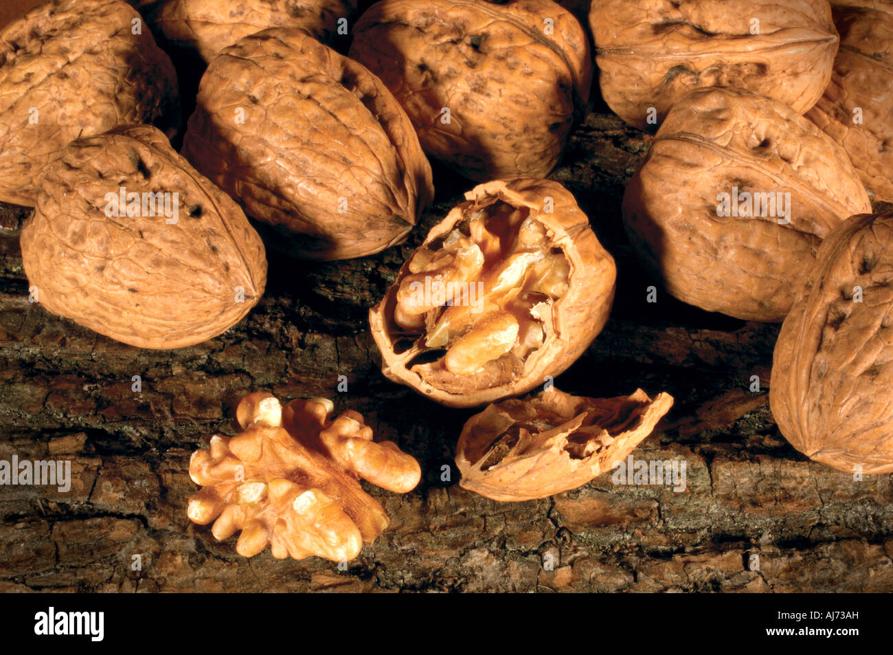 whole walnuts one cracked open with broken shell Stock Photo