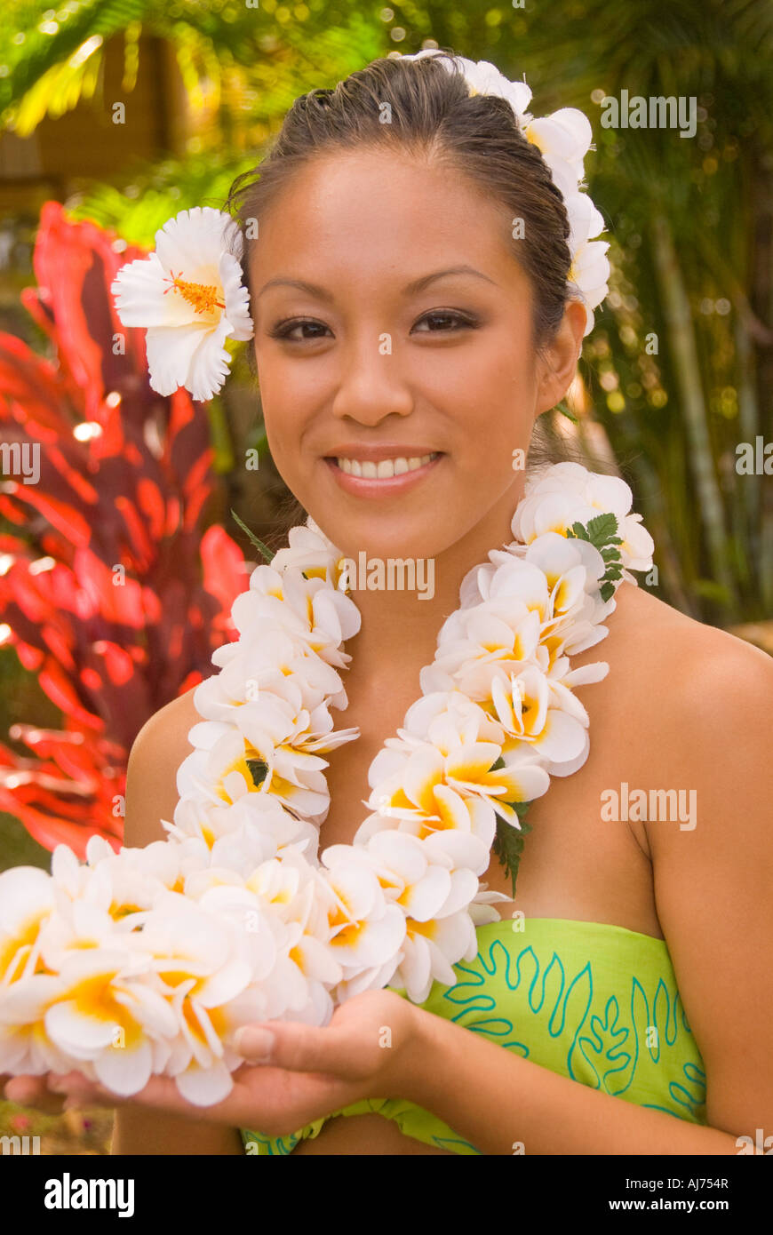 Hawaii Kauai Portrait of attractive Hawaiian female hula dancer in native dress wearing a colorful 'lei' of garland flowers Stock Photo