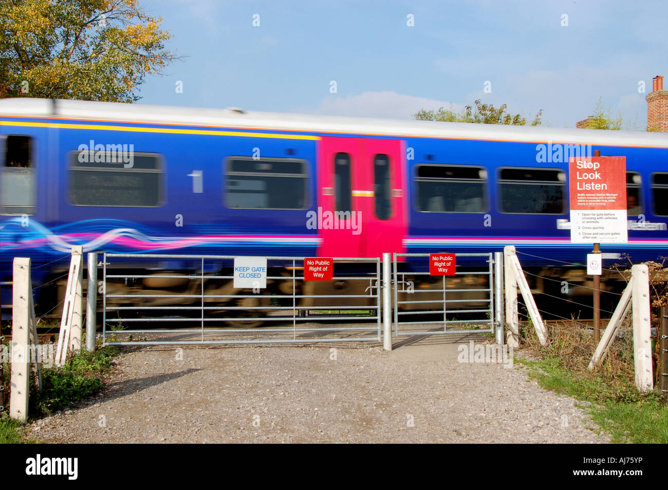 Train passing unmanned level crossing, Bucks, UK Stock Photo