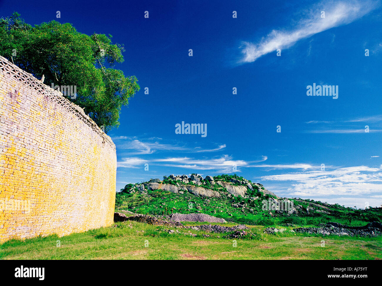 Eastern wall of Great Enclosure with Acropolis behind Great Zimbabwe Ruins Zimbabwe A rocky kopje is in the background Stock Photo