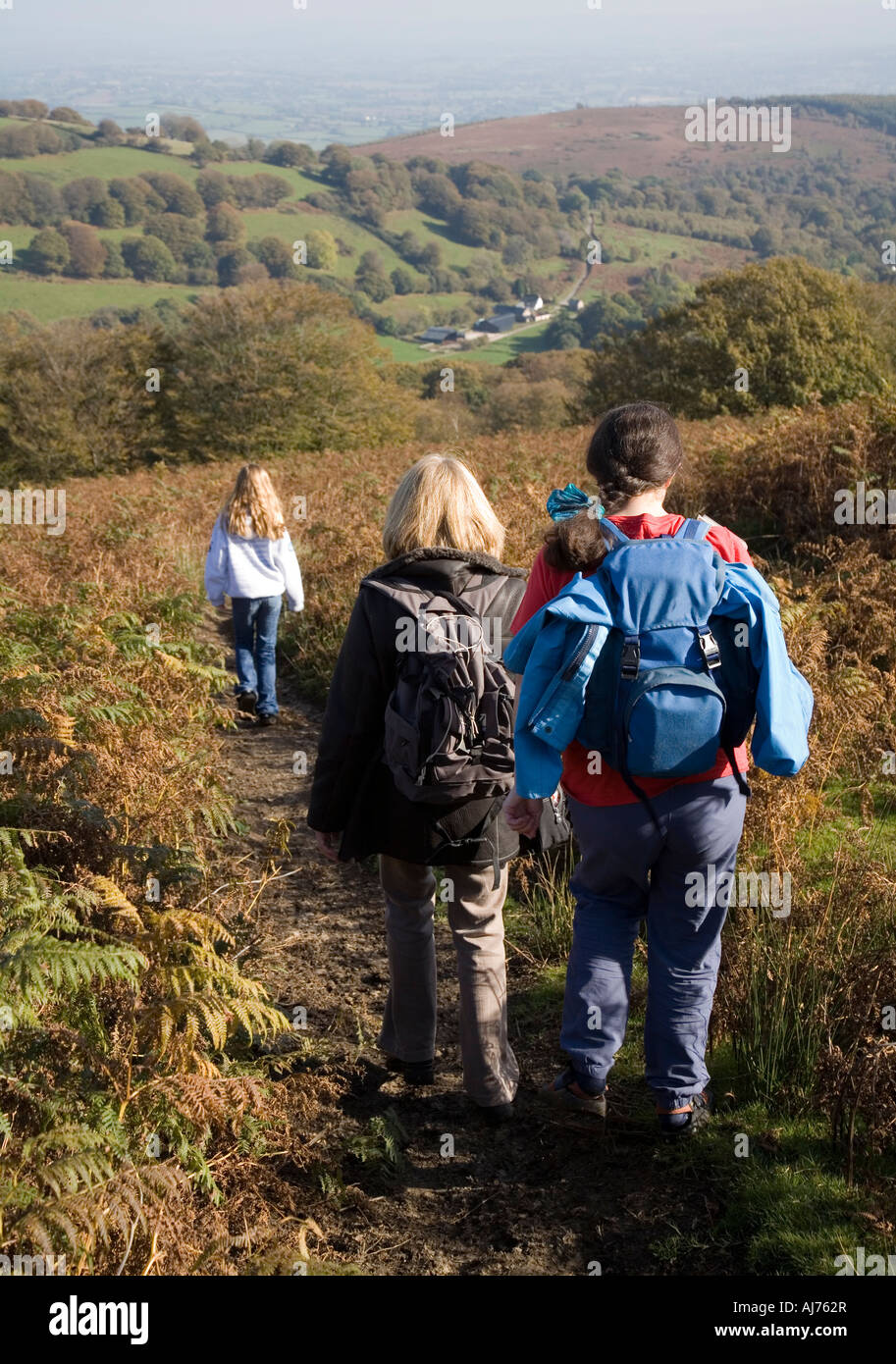 Three walkers two adults one child on the Carn y Gorfydd circular walk in the Nant Llanellen valley Wales UK Stock Photo
