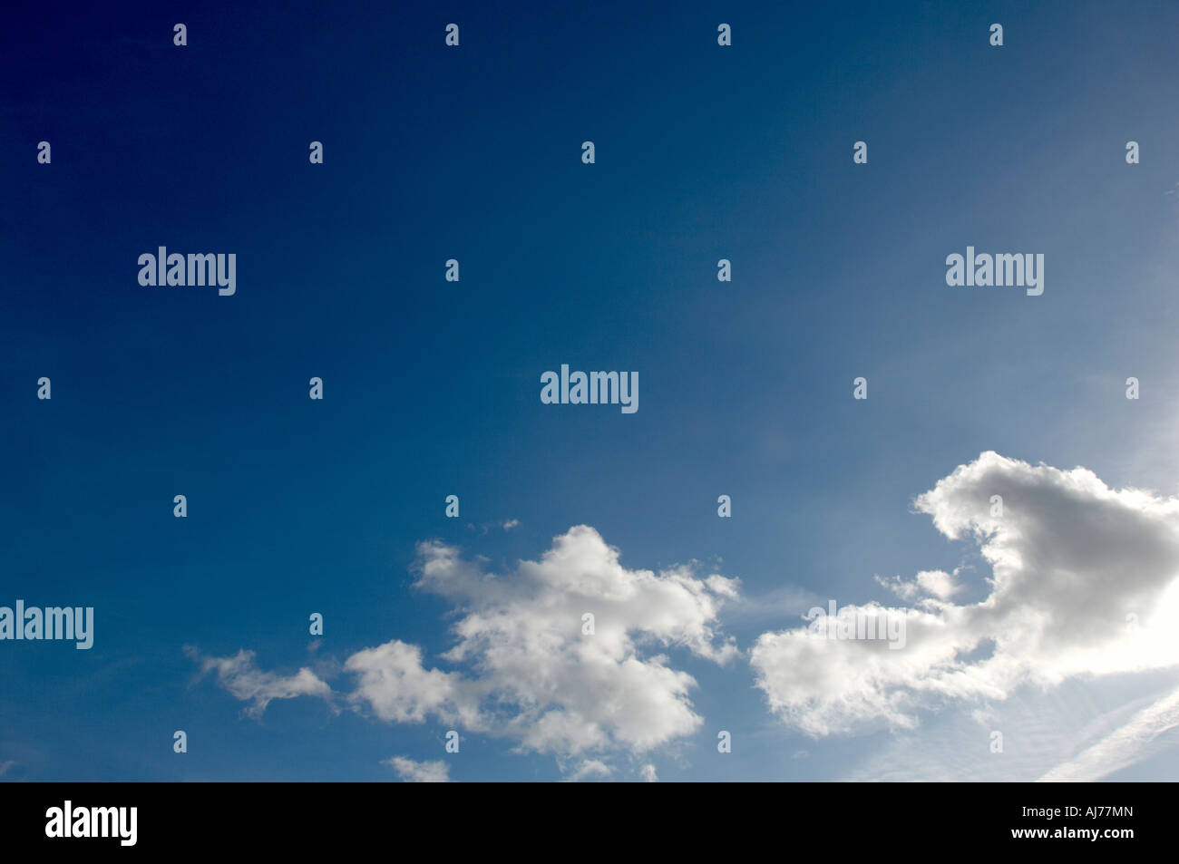 Bright sunny blue sky with fluffy clouds Stock Photo - Alamy