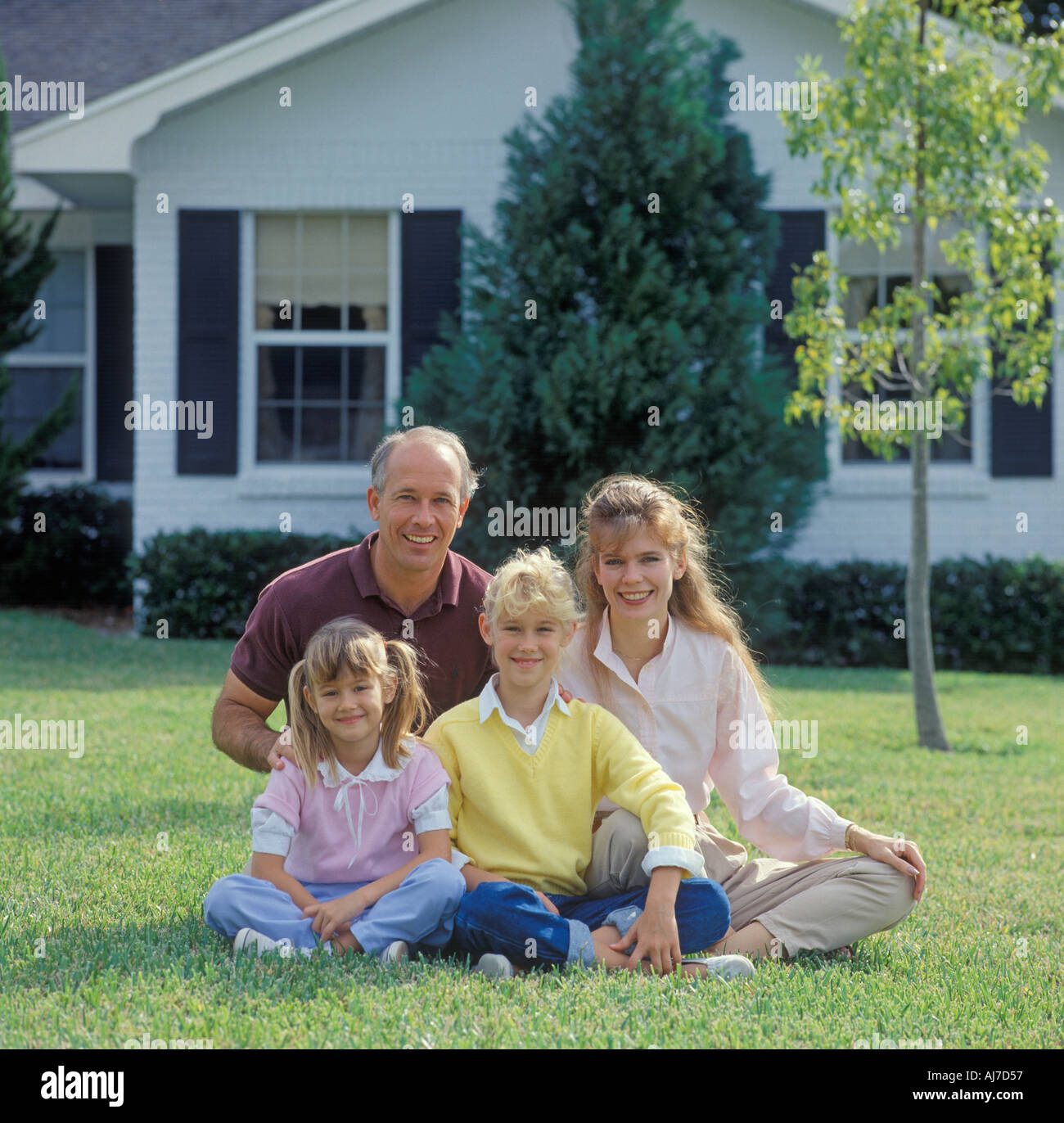 family of four relaxing on lawn Stock Photo
