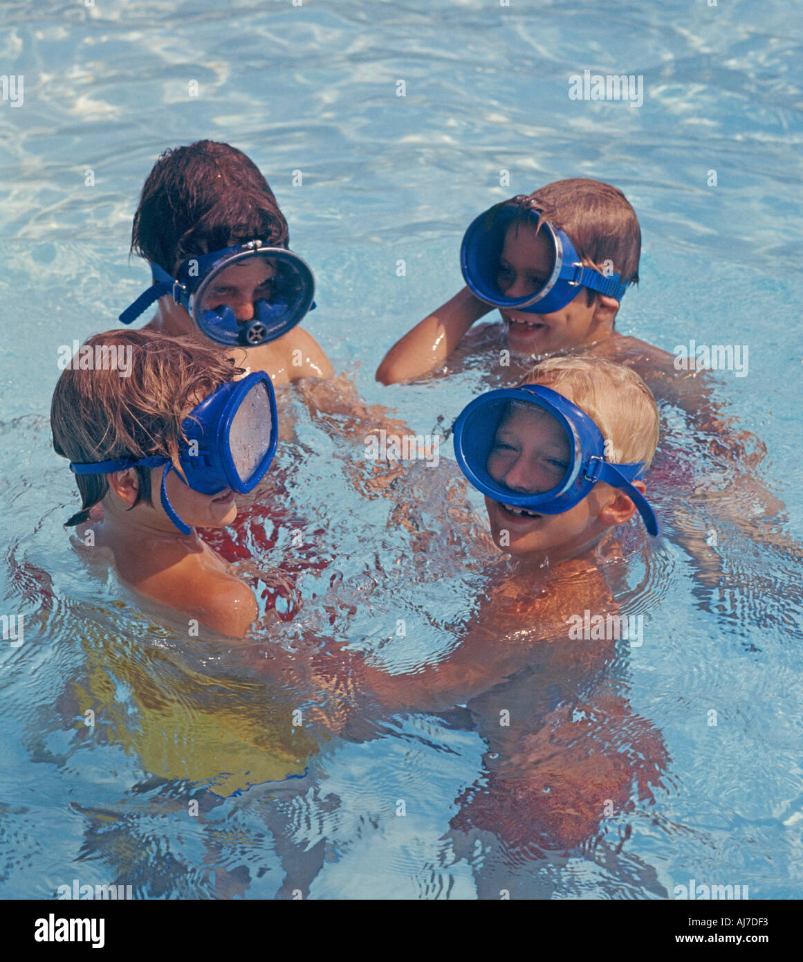 four young boys with dive masks playing in swimming pool Stock Photo