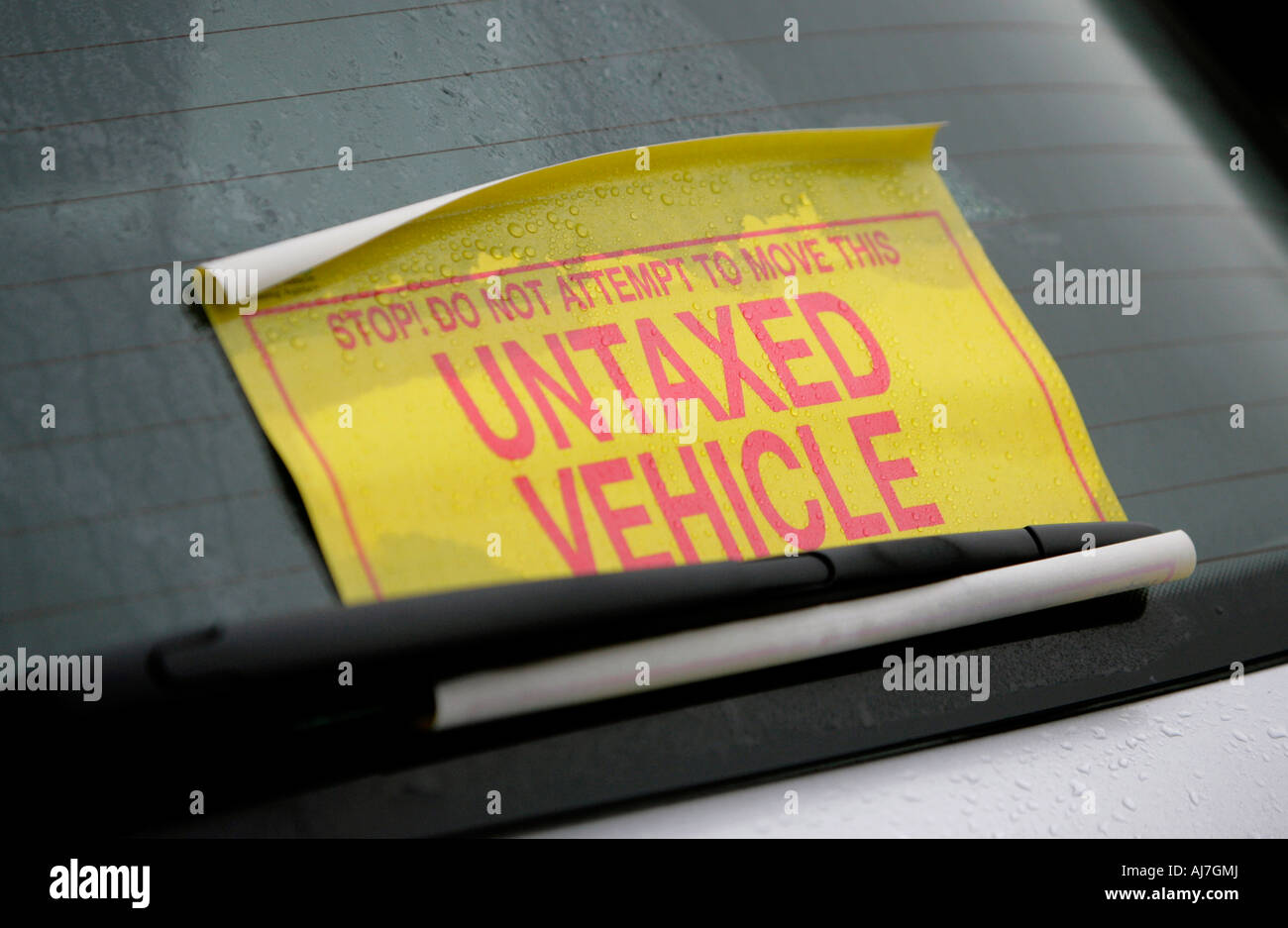 An untaxed vehicle notice is displayed on a vehicles windscreen. Stock Photo