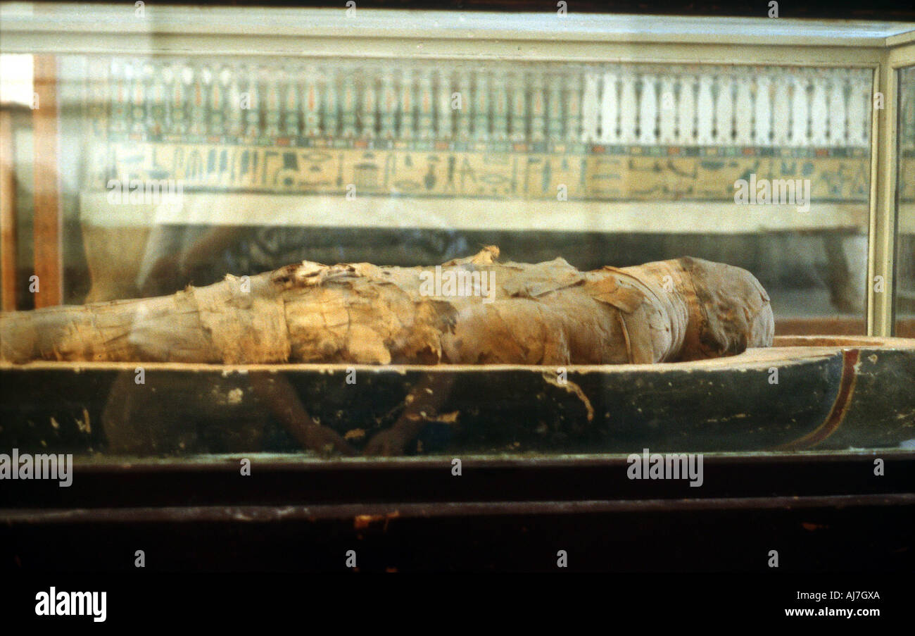 Mummy wrapped in bandages and lying on the base of a coffin, Ancient Egyptian. Artist: Unknown Stock Photo