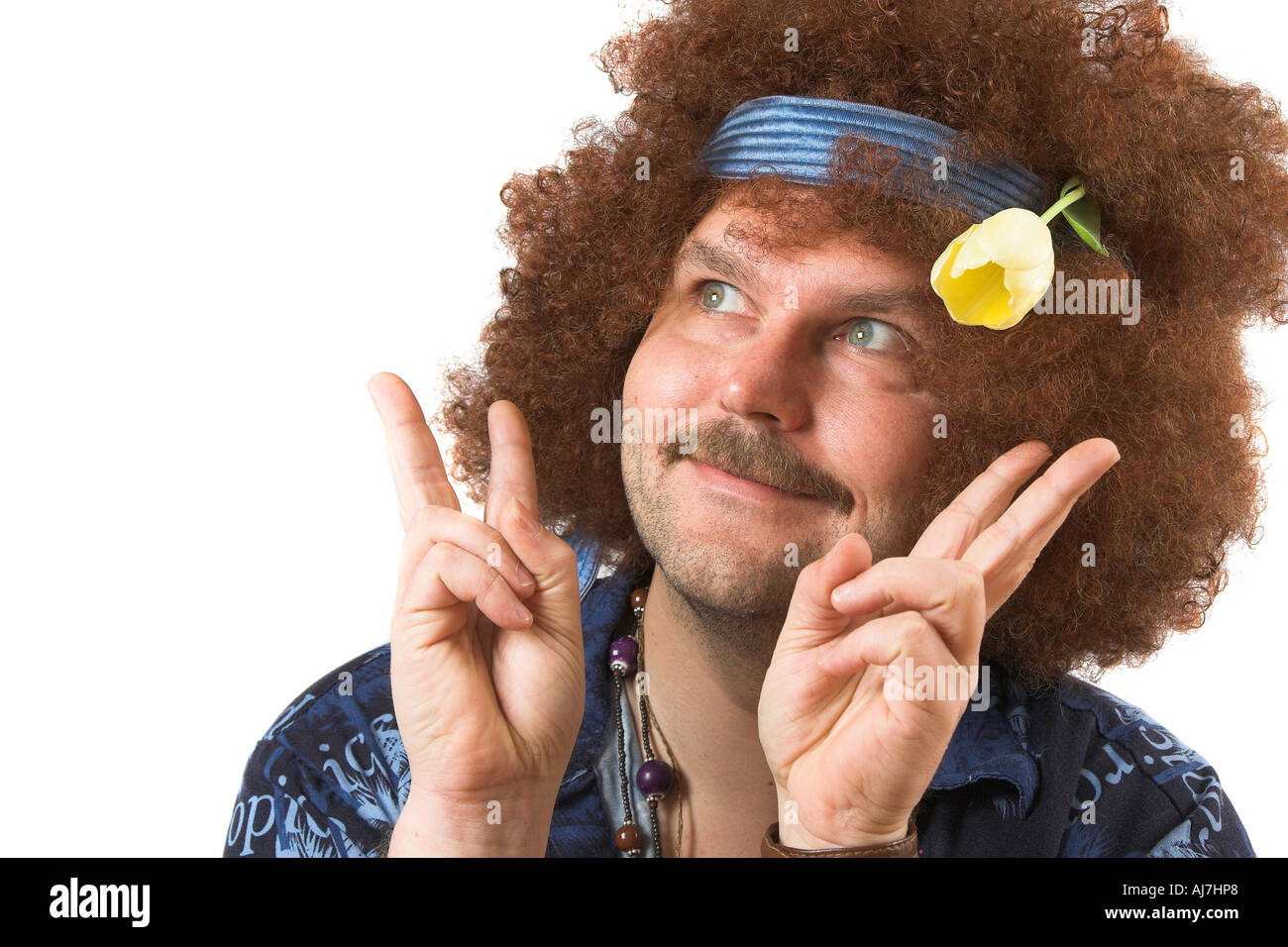 A slightly too old hippie making the peace sign with a tulip in his hair Stock Photo