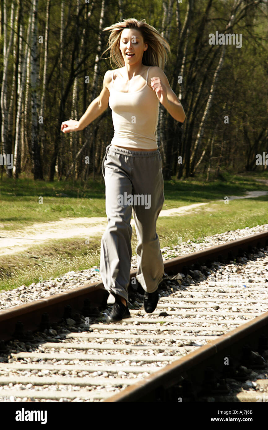 Woman jumping on railroad tracks Stock Photo Alamy