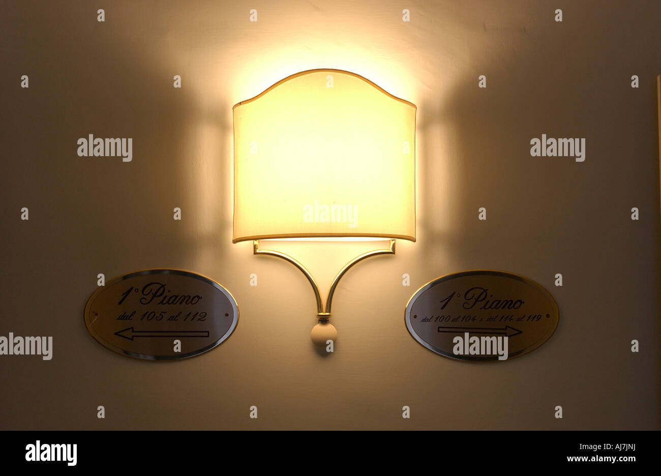 Hotel wall light with brass plaques indicating room locations Stock ...