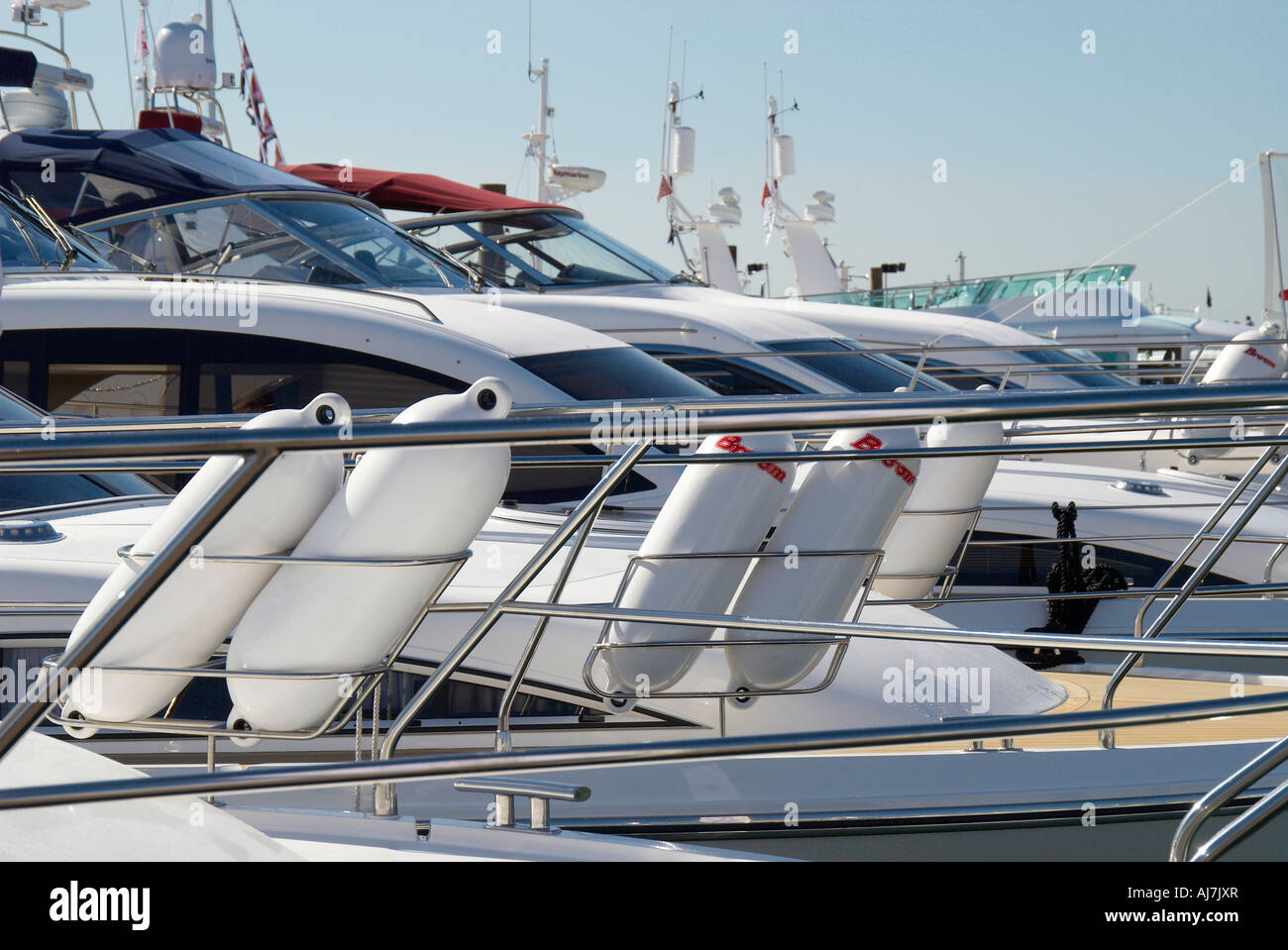 Fenders hanging on the rail of a luxury yacht set amongst other luxury