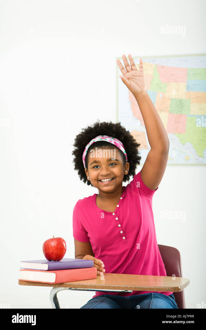 African American girl sitting in school desk raising hand and smiling ...