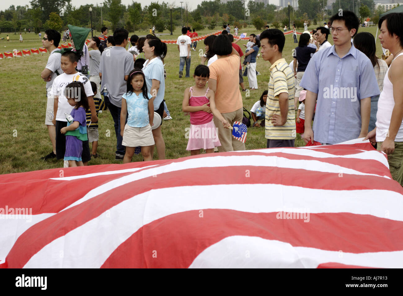 Asian families in front of American flag at Kite Festival in Liberty State Park across from Manhattan Stock Photo