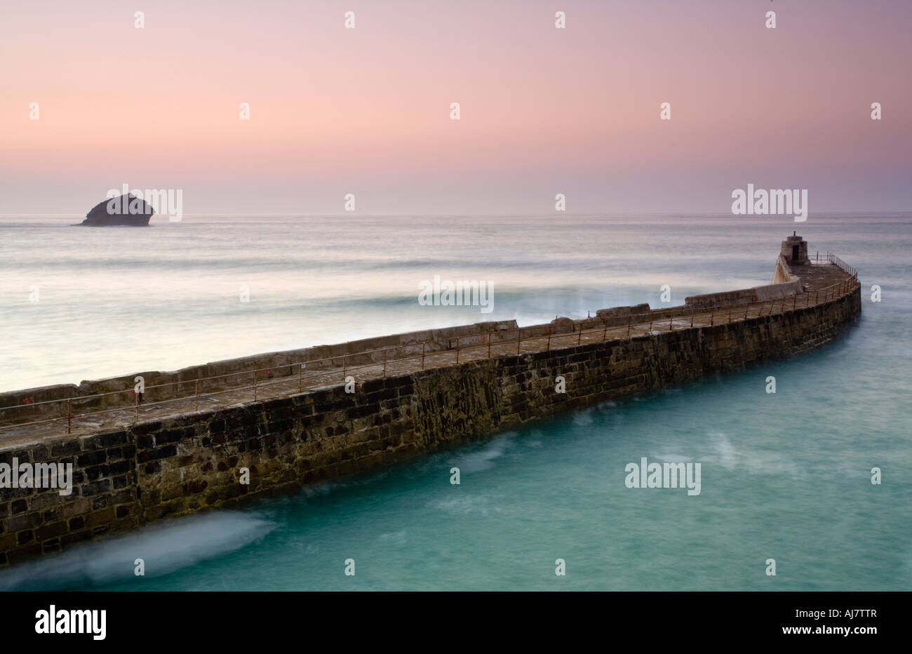 The pier at Portreath Cornwall England UK with Gul Rock to the left Stock Photo