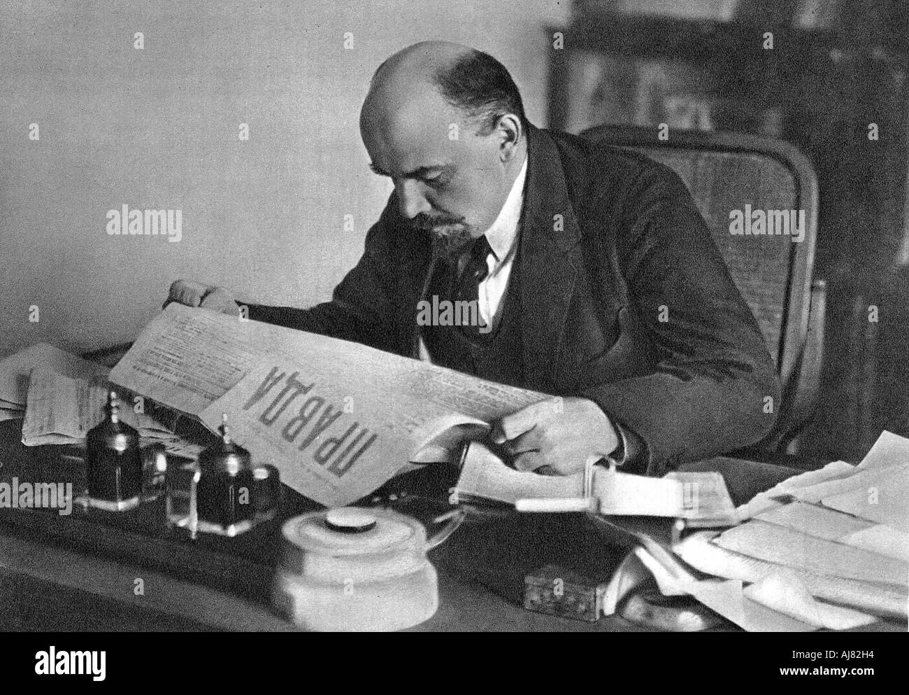 Vladimir Ilyich Ulyanov (Lenin), Russian Bolshevik revolutionary, reading Pravda, 1918. Artist: Unknown Stock Photo