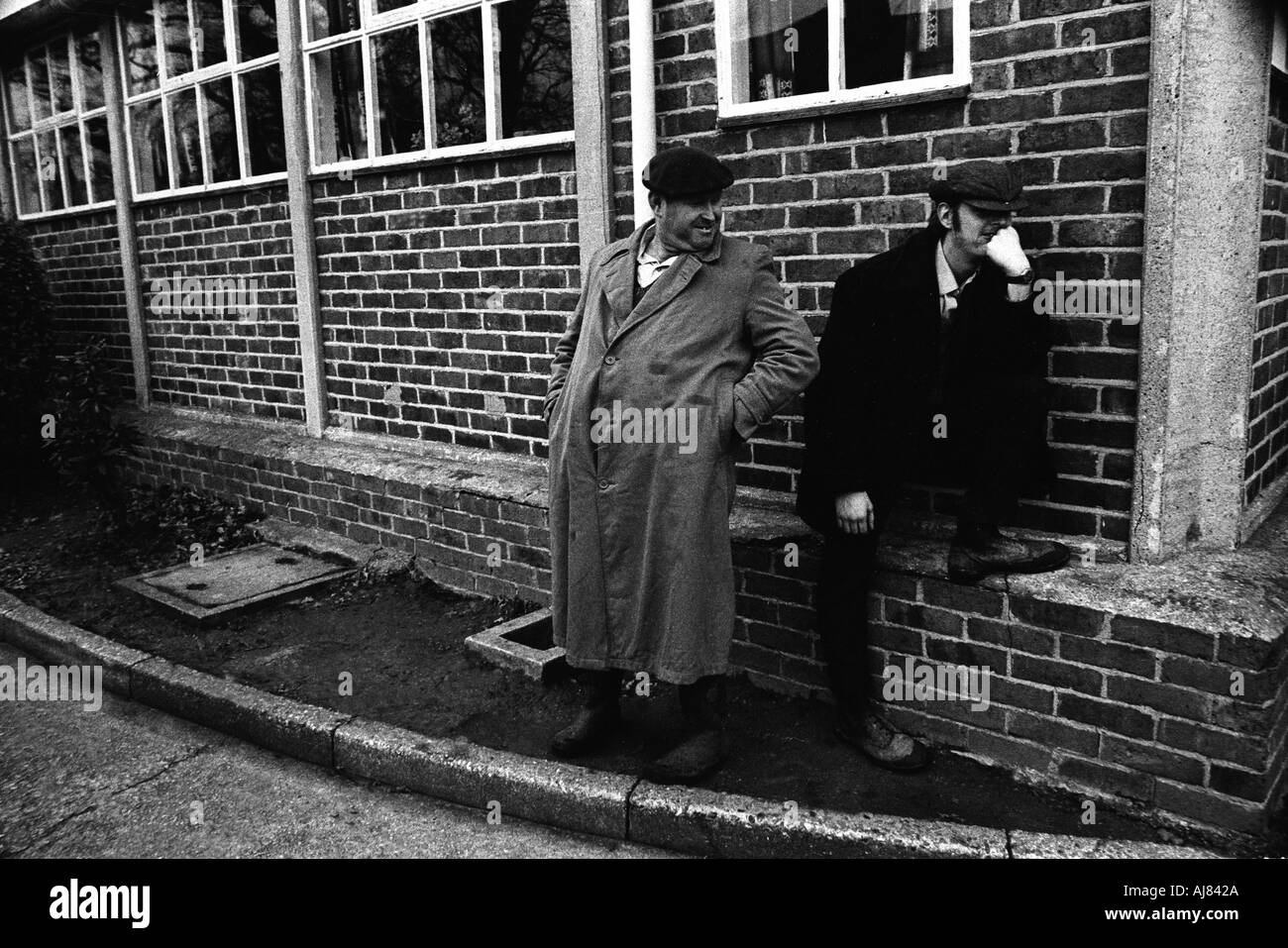 men standing around the grounds of a mental home called Botteleys Park soon to be closed down in the 1970's Britain. Stock Photo