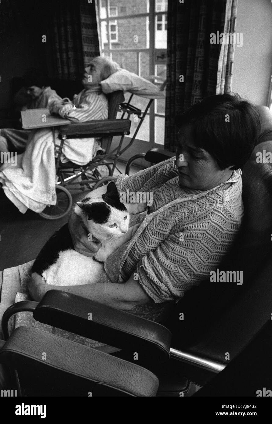 Woman with cat sitting in her room at mental home called Botteleys Park soon to be closed down in the 1970's Britain. Stock Photo