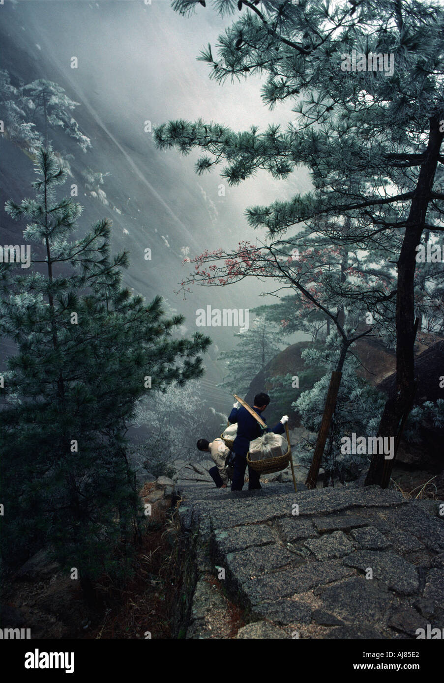 Porters are slipping on icy steps, Yellow Mountains (Huang Shan) in January, China Stock Photo