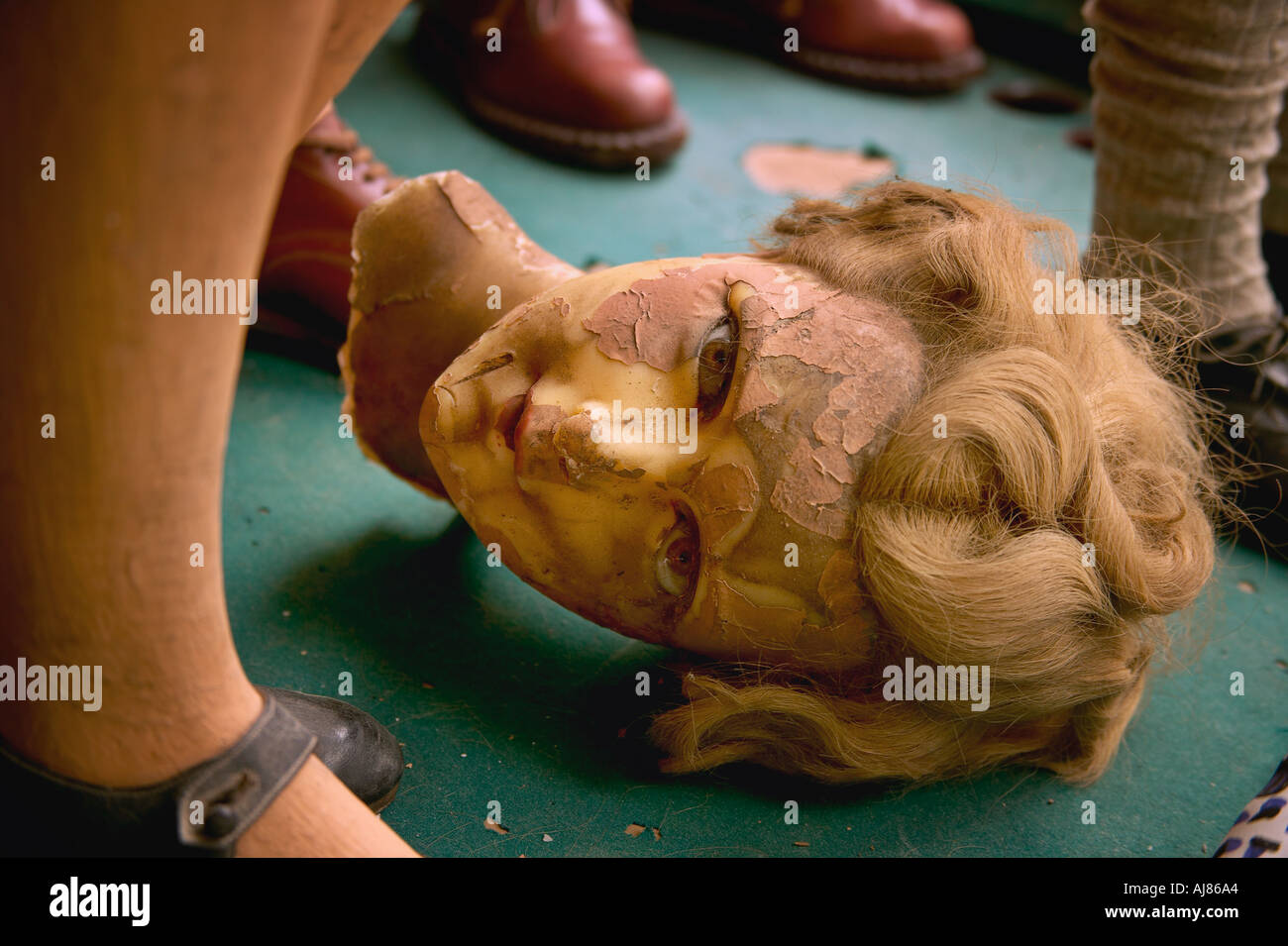 Wax mannequin head made in Belgium lays between mannequin legs and feet with shoes in shop window on West Broadway New York Stock Photo