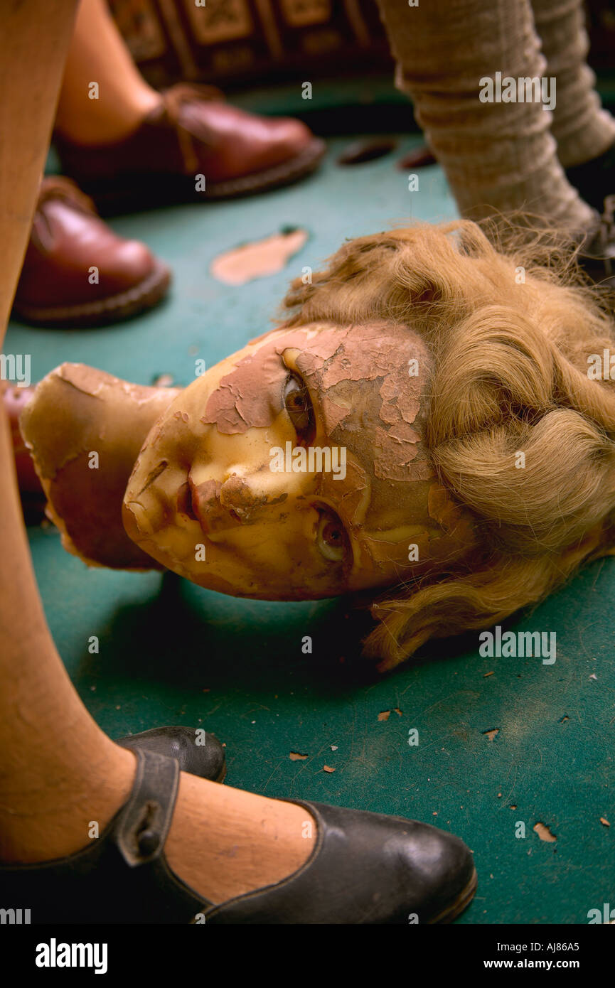 Wax mannequin head made in Belgium lays between mannequin legs and feet with shoes in shop window on West Broadway New York Stock Photo