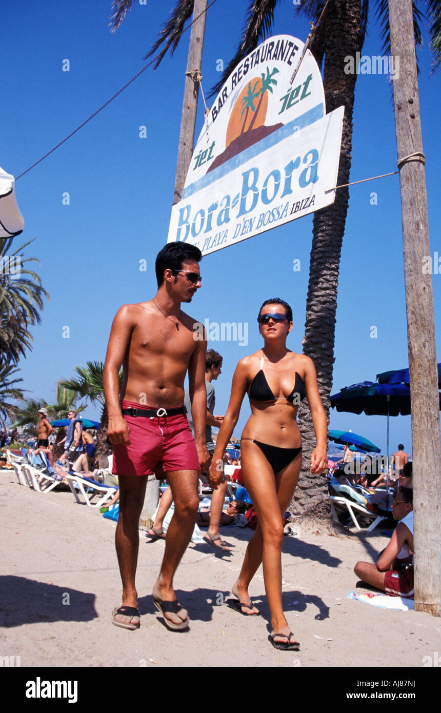 Couple walking over beach Bora Bora Beach Disco Platja d en Bossa Ibiza City Ibiza Balearic Island Spain Stock Photo