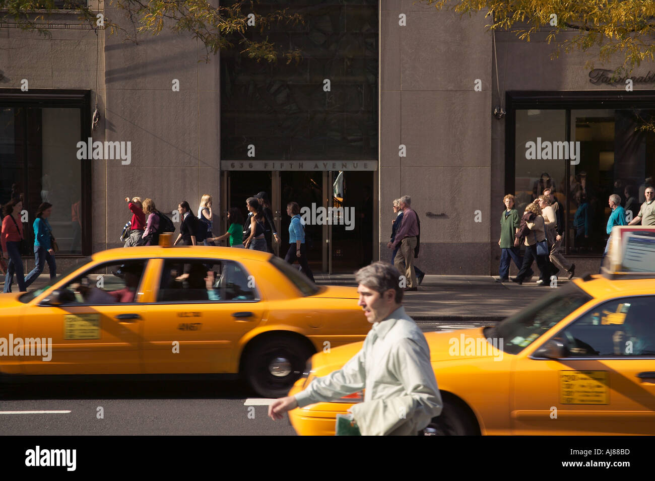 Taxis and pedestrians on Fifth Avenue traffic at Rockefeller Center in Midtown Manhattan New York NY Stock Photo