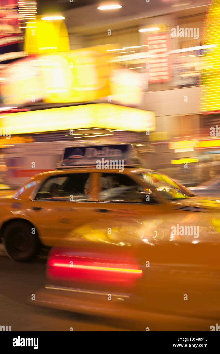 Taxi cabs rushing through Times Square Midtown Manhattan New York NY Stock Photo
