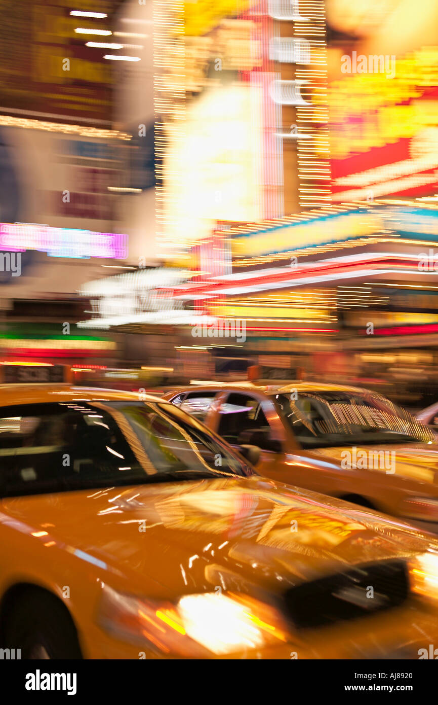Taxi cabs rushing through Times Square Midtown Manhattan New York NY Stock Photo
