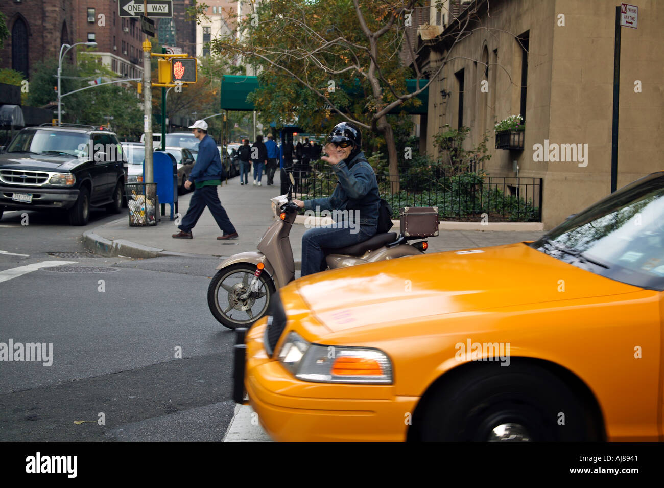 Motor scooter and taxi at intersection on 5th Ave in Greenwich Village New York NY Stock Photo