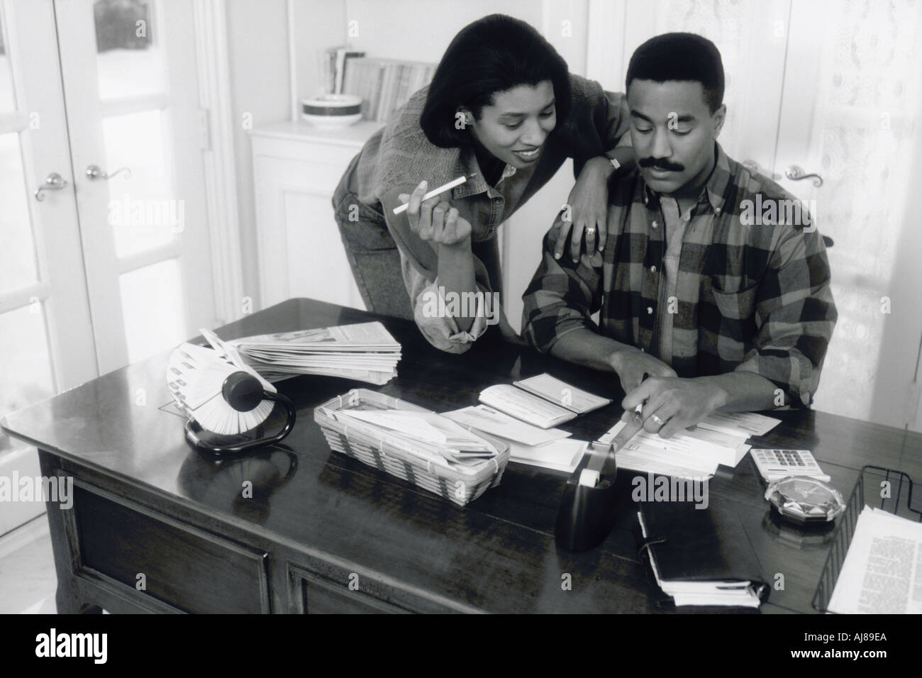 Black and white image of African American couple paying bills at home Stock Photo