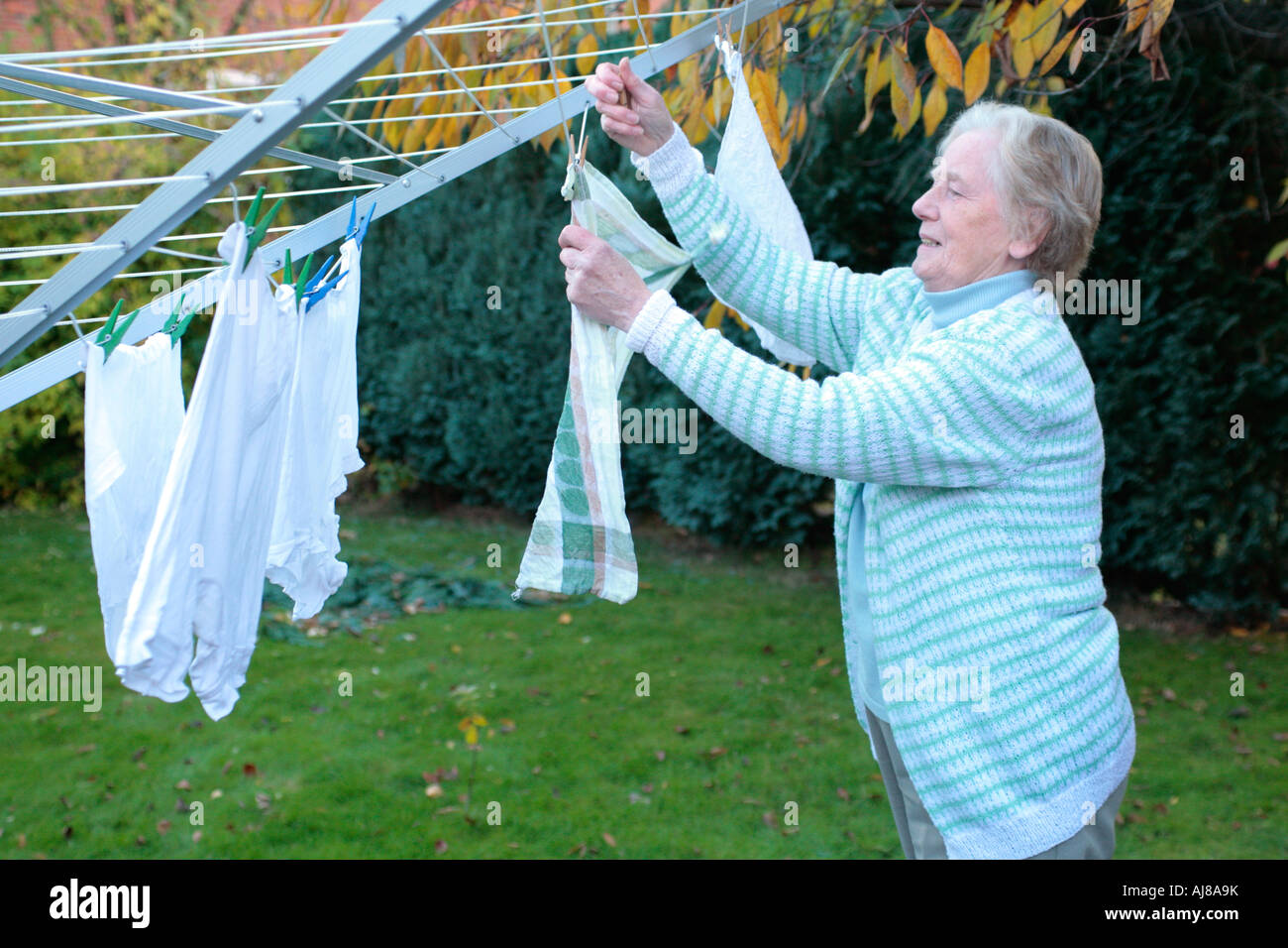 Elderly woman hanging up laundry hi-res stock photography and images - Alamy