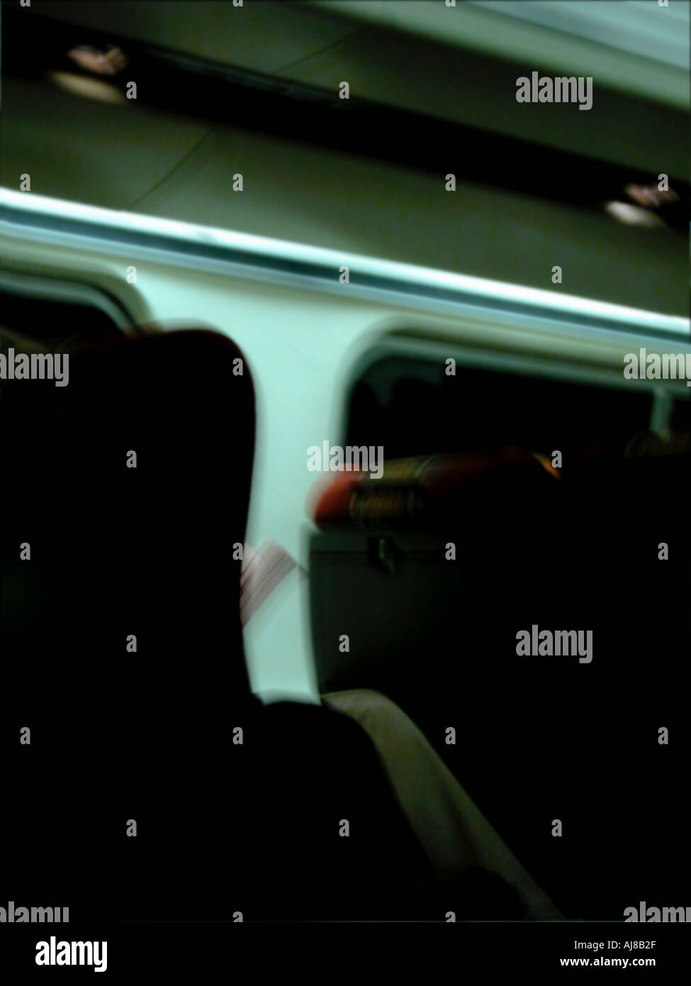 A business person relaxes reading newspaper while riding train at night ...