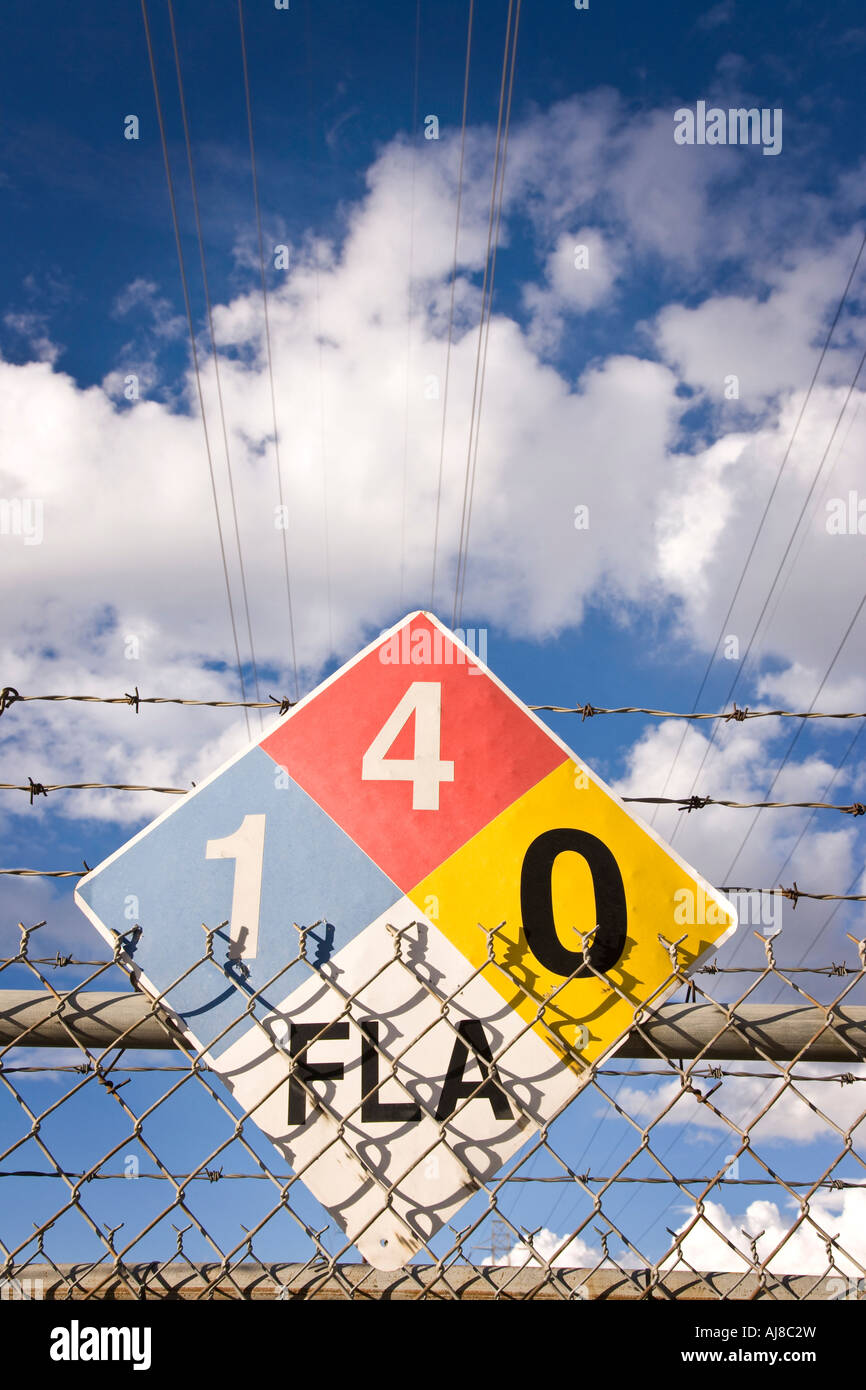 Road sign on wired fence with blue sky. Stock Photo