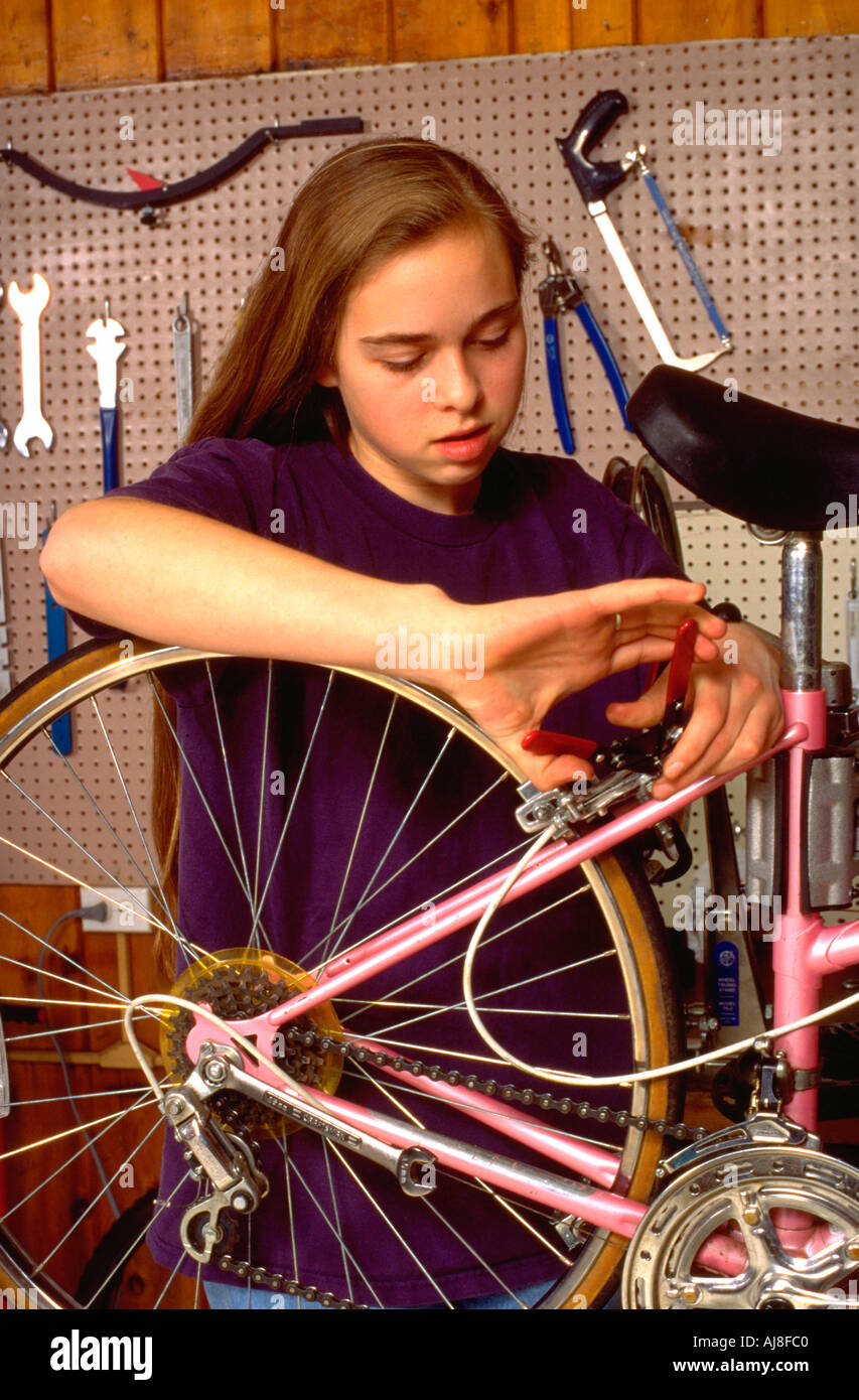 Girl age 14 repairing a bicycle at Youth Express bike shop. St Paul Minnesota USA Stock Photo
