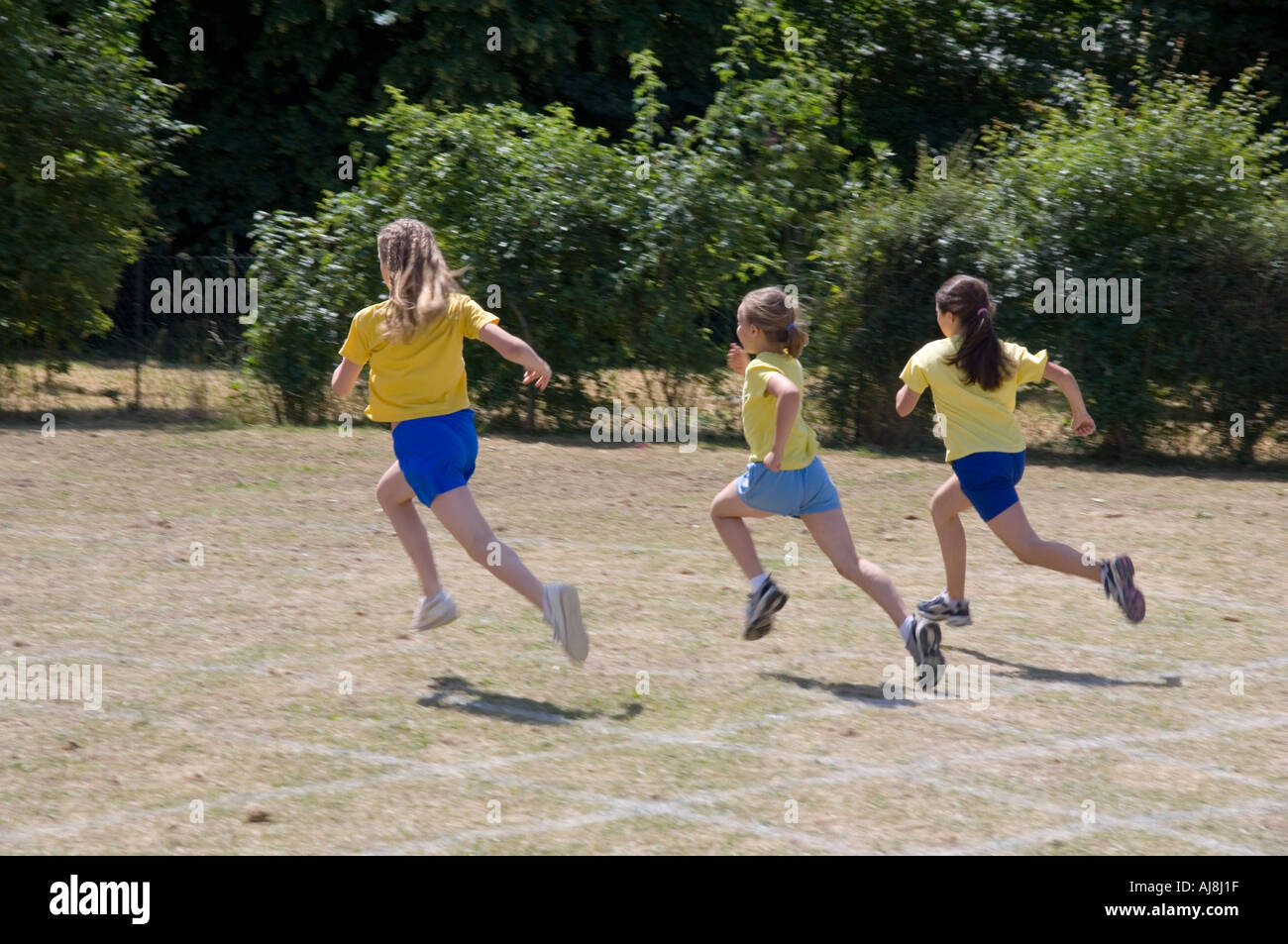 three girls racing in junior school sports day race Stock Photo