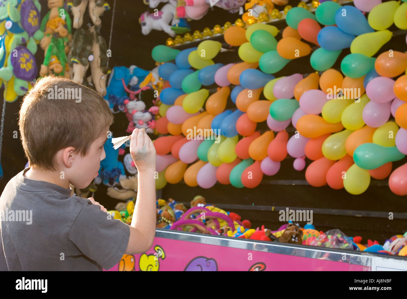 Detroit Michigan A boy aims a dart at balloons in a game at the Michigan State Fair Stock Photo