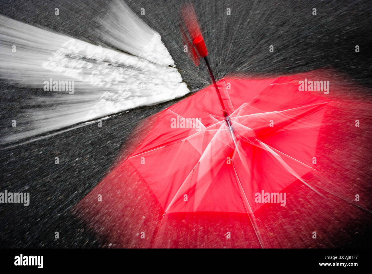 A white arrow pointing to a red umbrella Stock Photo