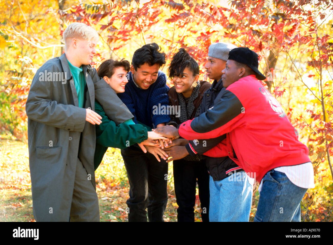 Racially mixed teens with Korean exchange student age 15 in circle with hands joined together.  St Paul Minnesota USA Stock Photo