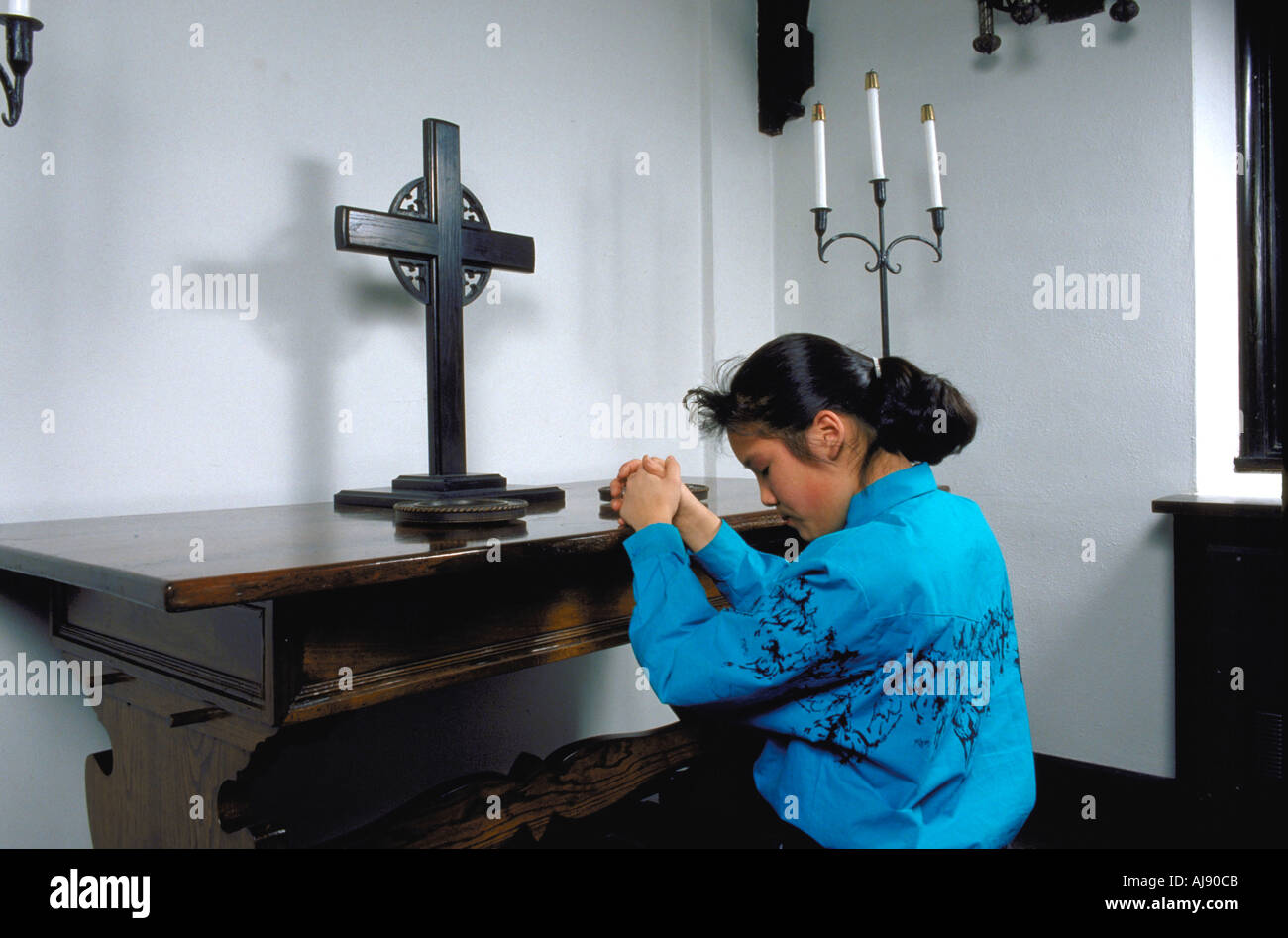 Girl kneeling praying in church hi-res stock photography and images - Alamy